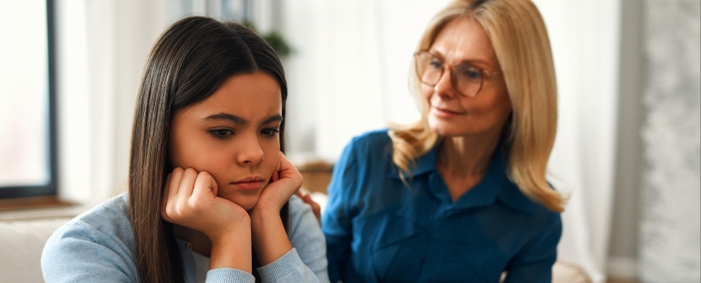 Vista de cima de pés com sapatilhas sobre pavimento com setas desenhadas em várias direções, representando diferentes caminhos possíveis.